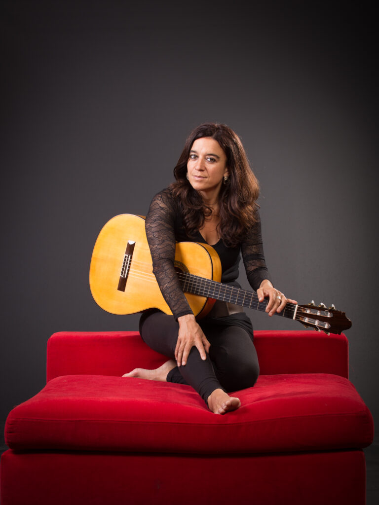 Portrait photo of Roxana Mourino and her guitar