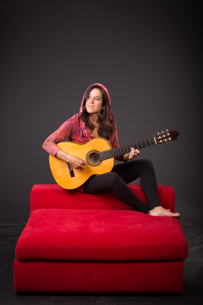 Portrait photo of Roxana Mourino and her guitar